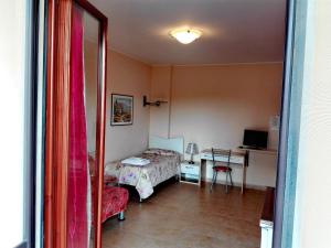 una camera con letto, tavolo e scrivania di B&B Casa Murgiana a Gravina in Puglia