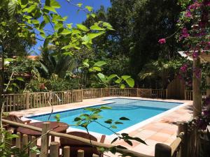 einen Pool in einem Garten mit Bäumen und Blumen in der Unterkunft Cheiro Nativo - Chalés & Pousada in Trancoso