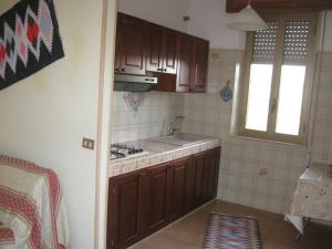 eine Küche mit braunen Schränken, einem Waschbecken und einem Fenster in der Unterkunft Valderice Vacanze for relax in Valderice