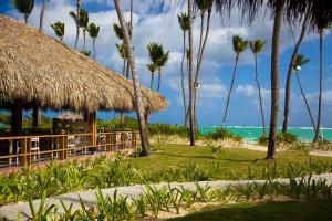 a restaurant on the beach with palm trees and the ocean at Grand Palladium Punta Cana Resort & Spa - All Inclusive in Punta Cana