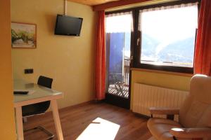 Zimmer mit einem Schreibtisch und einem Fenster mit Aussicht in der Unterkunft Katharinahof Ferienpension in Sibratsgfäll