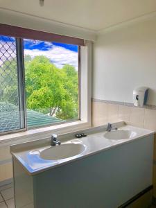 łazienka z 2 umywalkami i oknem w obiekcie Narrara Backpackers Hobart w mieście Hobart
