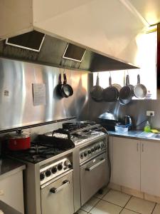 uma cozinha com fogão, panelas e frigideiras em Narrara Backpackers Hobart em Hobart