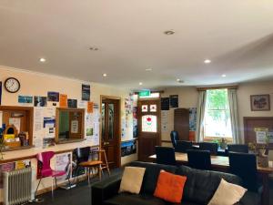 a living room with a couch and chairs at Narrara Backpackers Hobart in Hobart