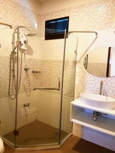 a bathroom with a glass shower and a sink at Must Come Boutique Hotel in Ban Nam Khong