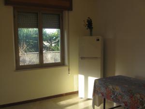 eine Küche mit einem Fenster, einem Kühlschrank und einem Tisch in der Unterkunft Valderice Vacanze for relax in Valderice