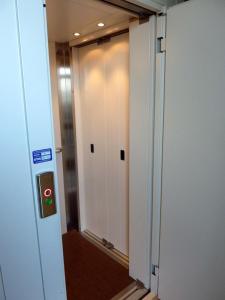 een lift in een kantoorgebouw met een glazen deur bij L'Ortolano Apartments in Spoleto