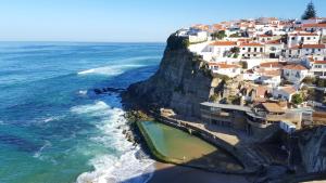 an aerial view of a village on a cliff next to the ocean at Magoito Beach Apartment in Sintra