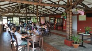 um grupo de pessoas sentadas em mesas em um restaurante em Hotel Huaka-yo em San Agustín