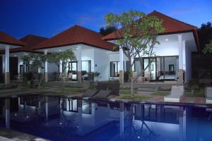 a house with a swimming pool in front of it at Tulamben Dive Resort in Tulamben