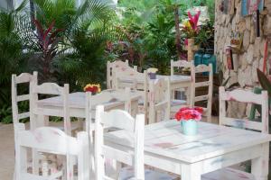 a white table and chairs with flowers on it at LiveTulum in Tulum