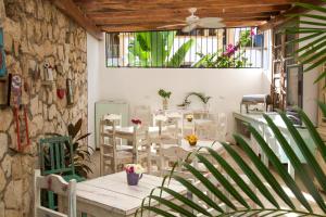 a patio with a table and chairs and a stone wall at LiveTulum in Tulum