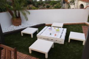 una mesa de picnic blanca y bancos en un patio en Casablanca, en Badalona