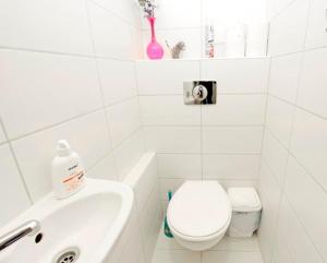 a white bathroom with a toilet and a sink at City Rooms in Budapest