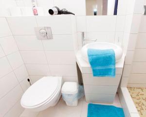 a small white bathroom with a toilet and a sink at City Rooms in Budapest