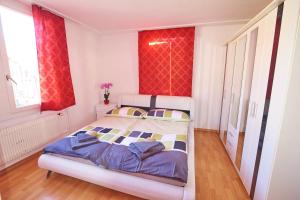 ein Schlafzimmer mit einem Bett in einem Zimmer mit roten Vorhängen in der Unterkunft New West Station 7 in Interlaken