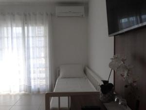 a small white room with a couch and a window at Pousada Natália in Torres