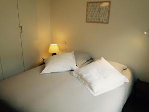 a bedroom with a bed with two white pillows at les pieds dans l'eau in Wimereux