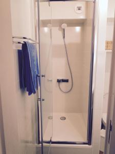 a shower with a glass door in a bathroom at les pieds dans l'eau in Wimereux