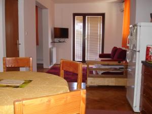 a room with a table and a kitchen with a refrigerator at Brko Apartment in Medulin