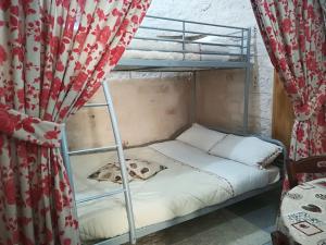 ロコロトンドにあるTrulli Manuelaのカーテン付きのドミトリールームの二段ベッド1台分です。
