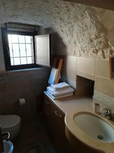 ein Bad mit einem Waschbecken, einem WC und einem Fenster in der Unterkunft Trulli Manuela in Locorotondo