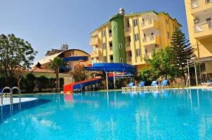 a large swimming pool with a slide in front of some buildings at Melissa Garden Apart Hotel in Side