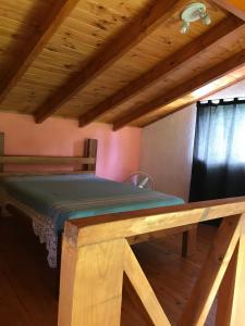 Cama en habitación con techo de madera en El Jacaranda 1 - Complejo en El Manzano