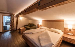 a bedroom with a large bed and a chair at Ferienhaus Larinmos in Lermoos
