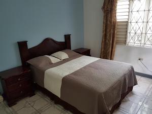 een slaapkamer met een bed en een raam bij Jus4U-1 The Home Away From Home Villa in Ocho Rios