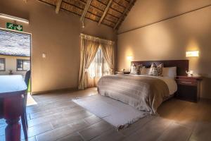 a bedroom with a bed and a large window at Ritsako Game Lodge in Klipdrift