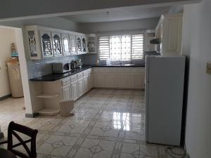 欧丘里欧Jus4U-1 The Home Away From Home Villa的厨房配有白色冰箱和窗户