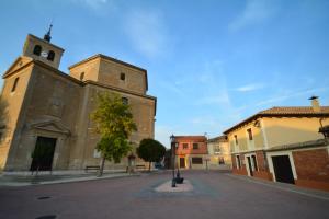 an empty street with two towers and a church at Casa Rural La Plaza in Valoria la Buena