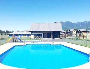 a large blue swimming pool in front of a house at Casa en Pucón in Pucón