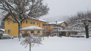 um pátio coberto de neve com um edifício amarelo em Hotel Castello em Montjovet