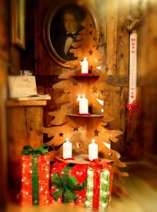 Hotel Chalet La Meridiana في سانت بييرّي: غرفة فيها هدايا وشموع وشجرة عيد الميلاد