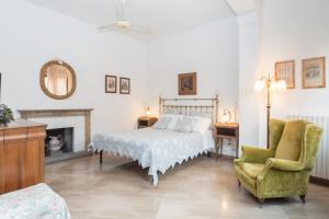 a bedroom with a bed and a chair and a fireplace at Cristina Rossi Bed&Breakfast in Bologna