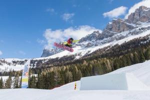 snowboarder robi sztuczkę w powietrzu w obiekcie Majon de la nona w mieście Pozza di Fassa