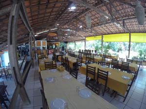 a dining room with tables and chairs and tablesktop at Pousada Pedra Grande in Morros