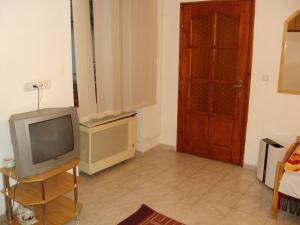 a living room with a tv and a door at Erik Apartments in Budapest