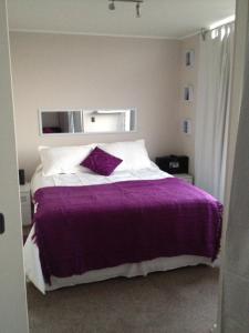 1 dormitorio con 1 cama con manta morada en Barcelo Suites Viña del Mar, en Viña del Mar