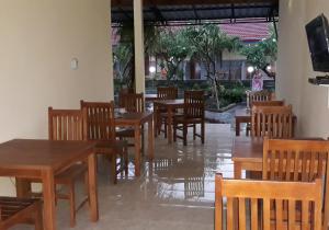 un ristorante vuoto con tavoli e sedie in legno di RedDoorz Plus @ Singaraja a Singaraja
