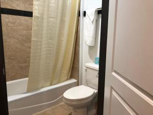 a bathroom with a toilet and a tub and a shower at Starlight Inn South El Monte in South El Monte