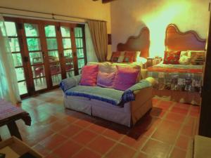 ein Wohnzimmer mit einem Stuhl und einem Bett in der Unterkunft Cissus Hotel Boutique in Antigua Guatemala