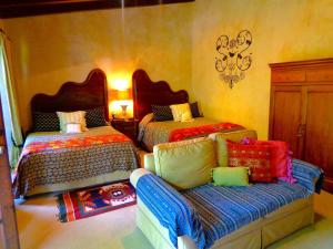 アンティグア・グアテマラにあるCissus Hotel Boutiqueのベッドルーム1室(ベッド2台、ソファ付)