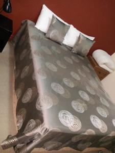 a bed with a gray bedspread with white pillows at Hampton Court Apartments in Brisbane