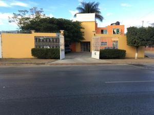 een geel gebouw met een hek aan de straatkant bij Hotel Tierra del Sol Oaxaca in Oaxaca City
