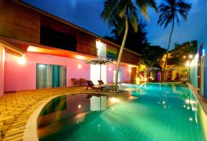 - une piscine en face d'une maison la nuit dans l'établissement Dickman Resort "The Boutique Hotel", à Negombo