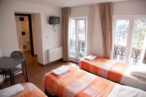 Cette chambre comprend 3 lits et un balcon. dans l'établissement Hotel Barry, à Bruxelles
