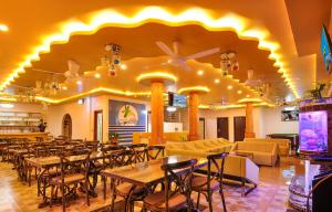 - un restaurant avec des tables et des chaises dans une salle dans l'établissement Sunrise Beach, à Maafushi